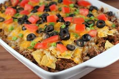 a casserole dish filled with ground beef, cheese and black olives