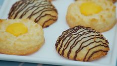 several cookies with chocolate drizzle and an egg in the middle on a white plate