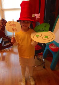 a little boy wearing a red hat and holding a sign that says sam i am