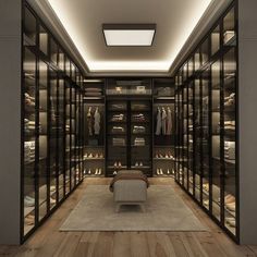 a large walk in closet with lots of clothes on shelves and lights above the doors