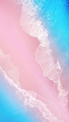 an aerial view of the ocean with pink and blue waves