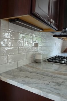 a stove top oven sitting inside of a kitchen next to wooden cabinets and counter tops