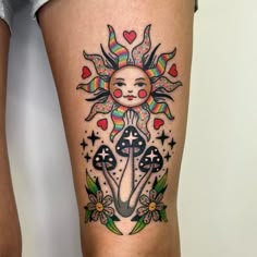 a woman's thigh with an artistic tattoo design on it and the sun above her head