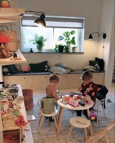 two children sitting at a table in a room