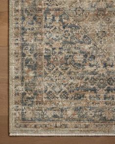 an area rug that is on top of a wooden floor with a brown and blue pattern