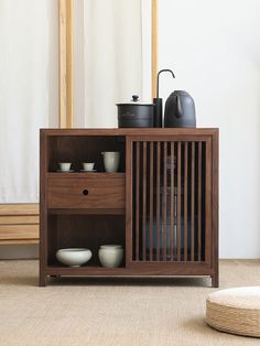 a wooden cabinet with bowls and cups on it