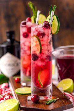 two glasses filled with cranberry lemonade and rosemary garnish on a cutting board