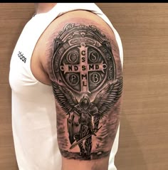 a man with a cross and angel tattoo on his arm