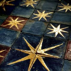 some gold stars on a blue and brown tile floor