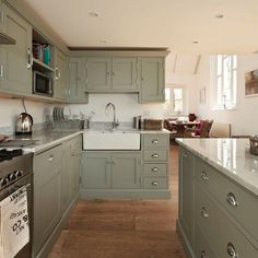 a kitchen with green cabinets and white counter tops