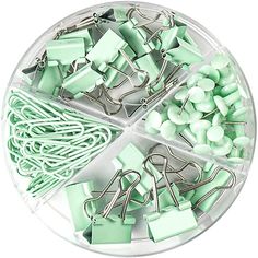 green binders and clips are arranged in a circular tray on a white surface with clippings