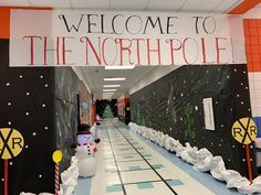 a hallway decorated for the north pole with snowmen and christmas trees on each side