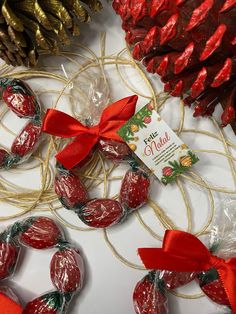 chocolate covered strawberries tied to twine with red ribbon and pine cones in the background