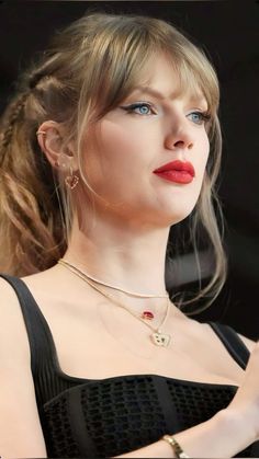 a close up of a person wearing a necklace and earrings with her hand on her hip