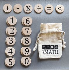 wooden numbers and dices are laid out on a table with a drawstring bag