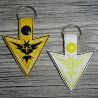 two keychains with different designs on them, one is yellow and the other is black