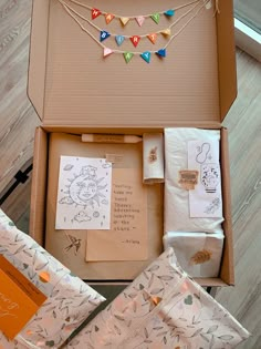 an open box with various items in it on the floor next to some cards and envelopes