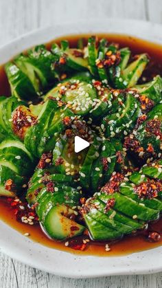 a white plate topped with green vegetables covered in sauce