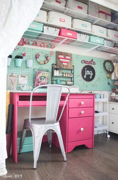 a pink desk and chair in a room with lots of storage containers on the wall