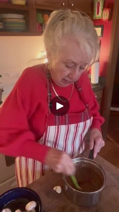 an older woman is cooking in the kitchen