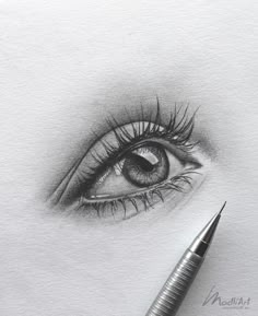 a pencil drawing of an eye with long lashes and the tip of a pen resting on top of it