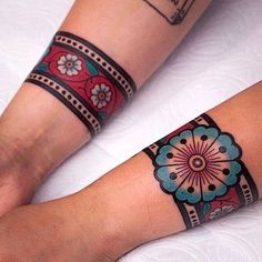 two people with matching tattoos on their arms and legs, one has a flower tattoo on it