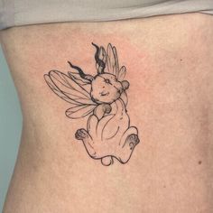 a woman's stomach with a small tattoo of a bee holding a teddy bear