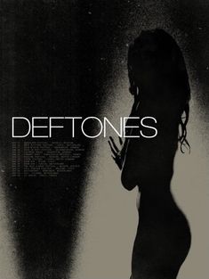 a woman standing in front of a wall with the words deftones on it