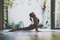 a woman is doing yoga on the floor in front of an open door with her hands behind her head