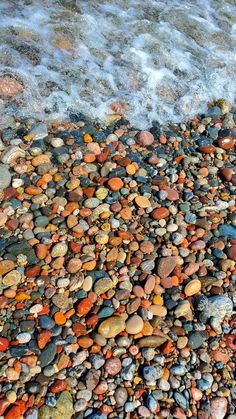 rocks and pebbles on the beach next to the water