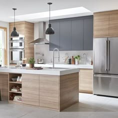 a modern kitchen with stainless steel appliances and wooden cabinets, along with white tile flooring