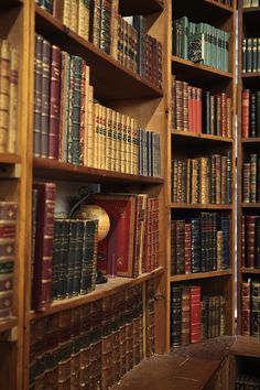 a bookshelf filled with lots of books next to a wooden bench