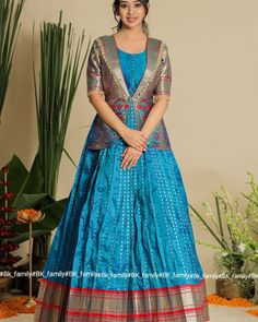 Meet the Bhoomi Pethani Jacket Dress, crafted from Pure Ban Paithani fabric, perfect for every occasion. It is 55 inches long with a 14.5-inch yoke for a comfortable fit. The dress has a flowing 4-meter flair and features Paithani work on the yoke and sleeves. The peplum-style top adds a modern touch to this traditional. Code: BK856N Name: Bhoomi Pethani Jacket Dress Fabric: Pethani Sleeve: Elbow Dress Length: 55inches Front Neck Length: 6.5inch Wash Care: Dry Wash Dress: The model is weari... Saree Dress Design Ideas, Long Blouse Designs, Long Tunic Dress, Simple Lehenga