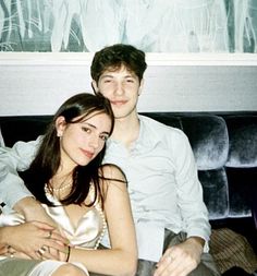 a young man and woman sitting next to each other on a couch