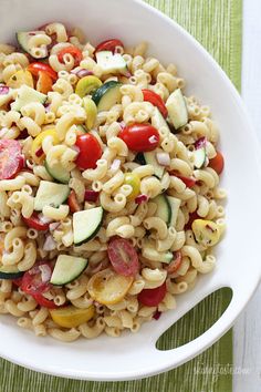 a white bowl filled with pasta salad on top of a table