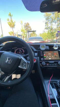 the interior of a car with an electronic display and steering wheel, dashboard, and dash board