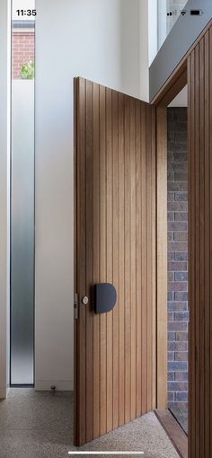 an open wooden door with a brick wall in the background