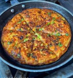 a pizza sitting in a pan on top of a stove