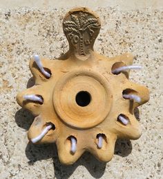 a ceramic object on the ground with holes in it