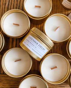 several small candles sitting next to each other on top of a wooden table with labels