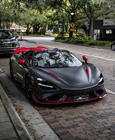 a black and red sports car is parked on the street