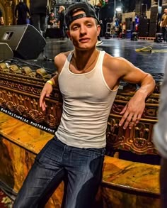 a man is posing for a photo in front of an ornately decorated bench with his hands on his hips