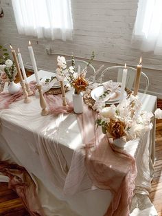 the table is set with flowers and candles