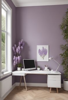 a white desk with a laptop on top of it next to a potted plant