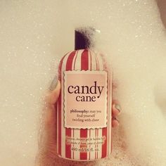 a person holding a bottle of candy cane in the bathtub