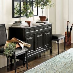 a living room with a table, chairs and potted plants on the top shelf