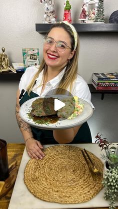 a woman holding a plate with food on it