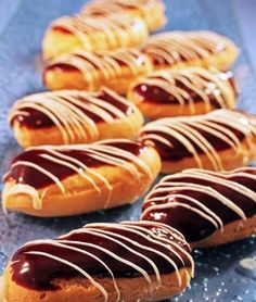 there are many donuts with chocolate drizzles on them, lined up