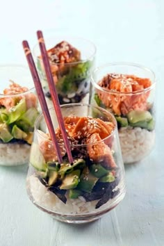 three small bowls filled with food and chopsticks on top of each other,