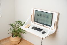 a computer monitor sitting on top of a white desk next to a keyboard and mouse